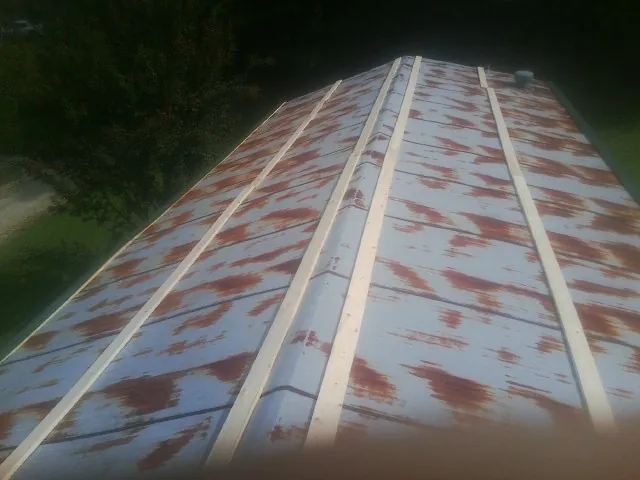 Rusted metal roof panels with new wood purlins before replacement — Storm Damage Roof Repair in Moravian Falls by Roofing Brothers