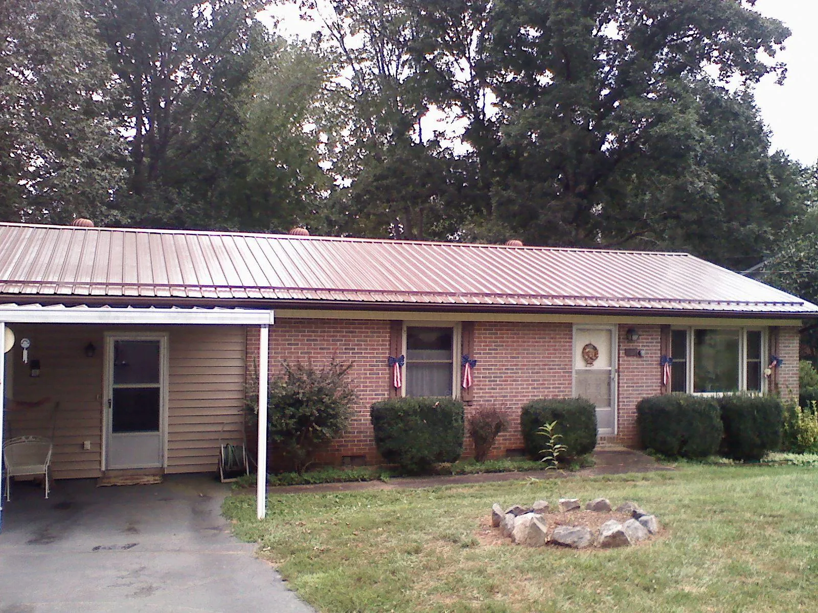 Bronze metal roof and carport on a brick ranch home — Roof Repair work by our crew in Moravian Falls